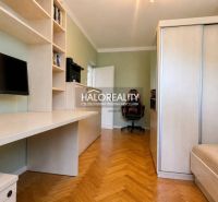 Ein Arbeitszimmer in einer 3-Zimmer-Wohnung mit Regalen, einem Tisch und einem Boden in Holzoptik.