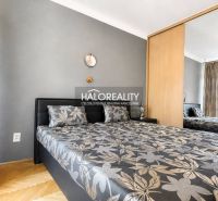 Schlafzimmer mit Doppelbett, Spiegelschrank und Holzboden in einer 3-Zimmer-Wohnung.