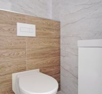 Toilette im Badezimmer eines Einfamilienhauses mit Marmor- und Holzverkleidungen.