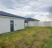 Ein Einfamilienhaus in Topoľnica mit weißer Fassade, Garten und Zaun.