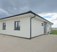 Ein Einfamilienhaus in Topoľnica mit weißer Fassade und gepflastertem Hof.