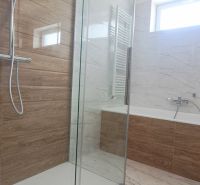 Ein Badezimmer mit einer modernen Dusche und einer Badewanne in einem Einfamilienhaus.