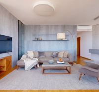 Ein stilvolles Wohnzimmer in einer 4-Zimmer-Wohnung mit Holzboden und bequemen Sitzgelegenheiten.
