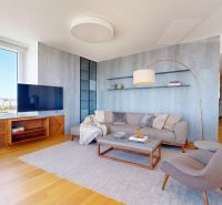 Wohnzimmer mit großem Fenster, Sofa und Fernseher, Boden mit Holzdekor.