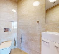 Badezimmer mit hellen Fliesen und weißem Waschbecken in einer 4-Zimmer-Wohnung.