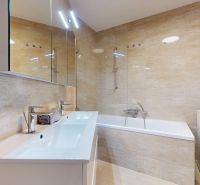 Badezimmer in einer 4-Zimmer-Wohnung mit Badewanne, zwei Waschbecken und Waschmaschine.