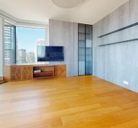 Wohnzimmer mit Glastüren, Holzboden und Aussicht in einer 4-Zimmer-Wohnung.
