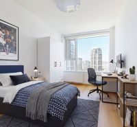 Schlafzimmer mit Bett, Schreibtisch und Aussicht in einer 4-Zimmer-Wohnung.