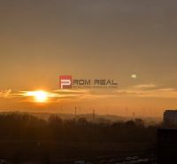 Sonnenuntergang über der Skyline vom Humenské námestie in Bratislava V mit Windturbinen.