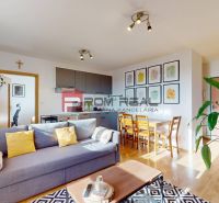 Wohnzimmer in einer Zweizimmerwohnung mit Holzboden und Zimmerpflanzen.