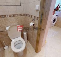 Badezimmer mit Toilette und Waschmaschine in einer 2-Zimmer-Wohnung. Normale Ausstattung und Keramikfliesen.