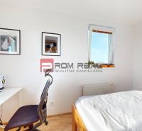 Schlafzimmer mit Tisch, Stuhl, Bett und Dekorationen in einer Zweizimmerwohnung.