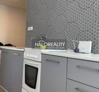 Küche in einer 2-Zimmer-Wohnung mit modernem Muster an der Wand und einem Boden in Holzoptik.