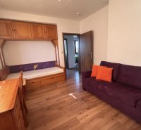 Ein Zimmer in einer 3-Zimmer-Wohnung mit einem Holzboden und einem regnerischen Ausblick aus dem Fenster.