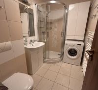 Badezimmer in einer 3-Zimmer-Wohnung mit Badewanne, Waschmaschine und Stauraum.