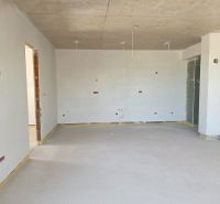 Ein Zimmer in einer 3-Zimmer-Wohnung mit Betondecke und nackten Wänden.