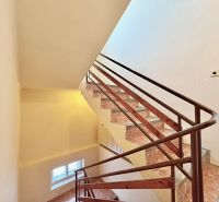 Eine Treppe mit braunem Geländer in einem Einfamilienhaus.