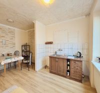 Küche in einem Einfamilienhaus mit Holzboden und Esstisch.