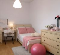 Ein Zimmer in einer 4-Zimmer-Wohnung mit Bett, Kommode, Schreibtisch und Dekorationen.