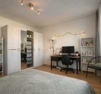Schlafzimmer mit Schreibtisch, Schränke mit Holzdekor in einer 4-Zimmer-Wohnung.