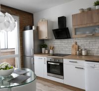 Helle Küche mit Geräten, Esstisch und Holzboden in einer 4-Zimmer-Wohnung.