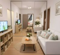 Wohnzimmer in einer 4-Zimmer-Wohnung mit einem bequemen Sofa und einem Spiegelschrank.