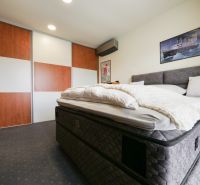 Schlafzimmer im Einfamilienhaus mit großem Bett und Schiebetürenschrank.