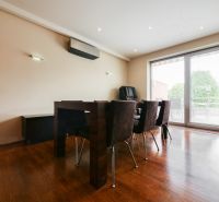 Esszimmer in einem Einfamilienhaus mit Holzboden und Glastüren zur Terrasse.