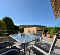 In Partizánske eine Terrasse eines Einfamilienhauses mit Gartenmöbeln und Blick ins Grüne.