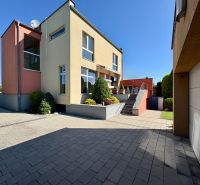 Ein Einfamilienhaus in Partizánske mit Garten, Terrasse und Garage auf einem befestigten Hof.