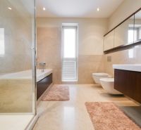 Ein Badezimmer im Einfamilienhaus mit Badewanne, Waschbecken und Spiegelschränken.