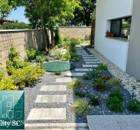 Ein Gartenweg im Einfamilienhaus in Senec, umgeben von Pflanzen und Steinen.