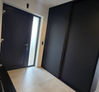 Eingangsflur in einem Einfamilienhaus mit dunkler Tür und großem Schrank.