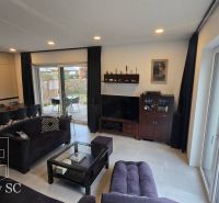 Wohnzimmer in einem Einfamilienhaus mit Sofa, Esstisch und Blick auf die Terrasse.