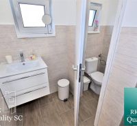 Badezimmer mit Waschbecken und Toilette in einem Einfamilienhaus, Boden mit Holzdekor.
