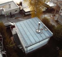 Hütte in Senec am SONNENSEE SÜD, mit Flachdach, umgebenden Bäumen und einer Straße.
