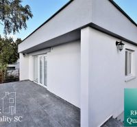 Die Terrasse des Einfamilienhauses an den Sonnenseen Süd in Senec mit Pflastersteinen und Geländer.