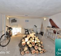 Keller eines Einfamilienhauses mit Fahrrad, Gartenmöbeln und gelagertem Brennholz.