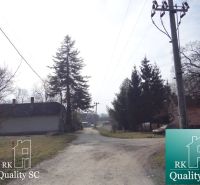 Landstraße in der Gegend des Alten Hafens Gabčíkovo, umgeben von Holzarchitektur und Grünflächen. Grundstücke - Wohnen.