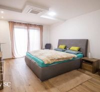 Ein Schlafzimmer in einem Einfamilienhaus mit einem Holzboden und minimalistischer Einrichtung.