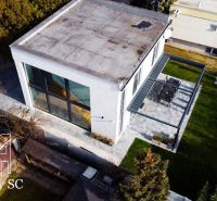 Ein Einfamilienhaus an den Sonnenseen Süd in Senec mit großen Fenstern und einer Terrasse.