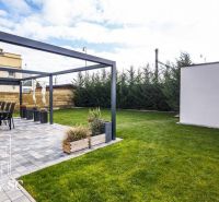 Der Garten eines Einfamilienhauses an den Sonnenseen Süd in Senec mit Terrasse und Rasen.