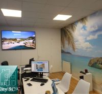 Interieur eines Einfamilienhauses mit Stranddekor, Tisch und Computern.