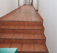 Flur mit Keramikfliesen und Treppe in einem Einfamilienhaus.
