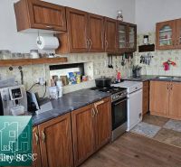 Eine Küche in einem Einfamilienhaus mit Holzschränken und einem Boden mit Holzdekor.