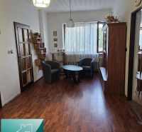 Innenraum eines Einfamilienhauses mit Sesseln, Tisch und Boden in Holzoptik.