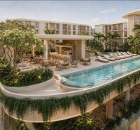 Wohnungsbau in Pattaya mit einem Pool auf der Terrasse, umgeben von üppigem Grün und Liegestühlen.