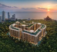 Wohnungsbau in Pattaya am Meer, umgeben von Grünflächen und hohen Gebäuden.