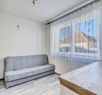 Ein Sofa und Schränke im Zimmer eines Einfamilienhauses, mit einem Boden in Holzoptik.