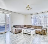 Wohnzimmer in einem Einfamilienhaus mit Sofa und Tisch, Boden mit Holzdekor.